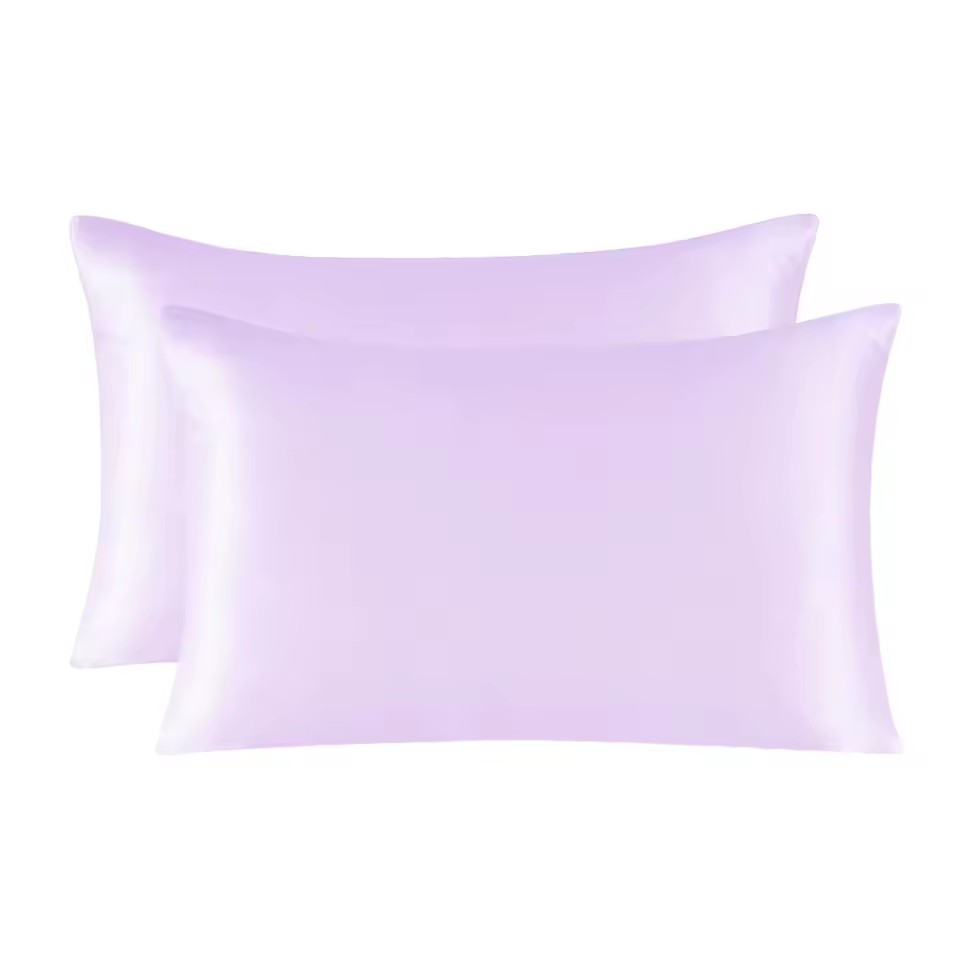 Two lavender satin pillowcases on a white background