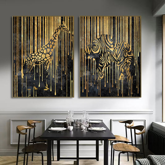 Two canvas prints featuring abstract animal designs, with gold and black colors, displayed on a wall in a dining room setting.