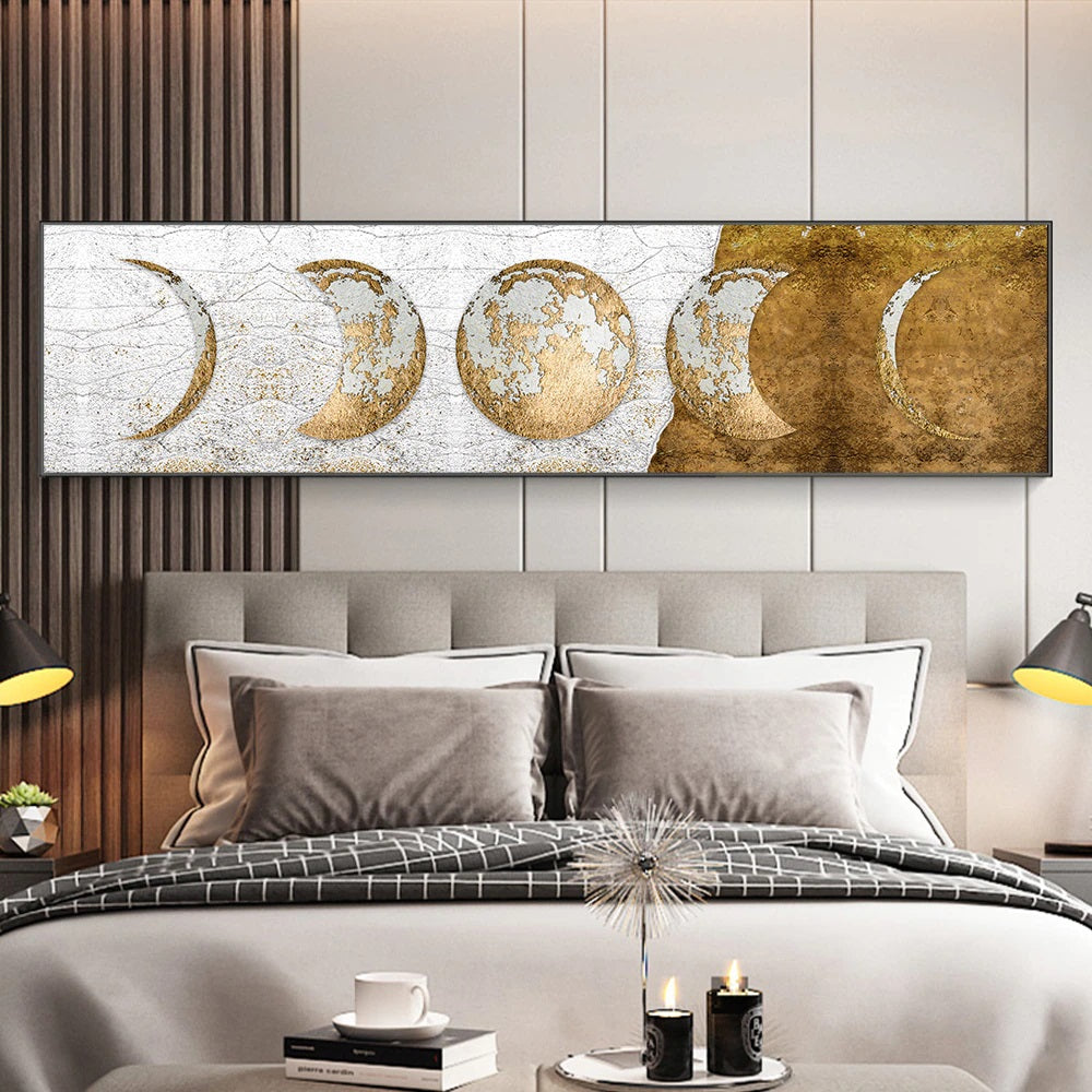 A canvas print featuring golden moon phases in a slim format displayed above a grey sofa in a modern living room setting.
