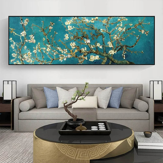 A canvas wall art reproduction of Van Gogh's Almond Blossom hanging above a grey sofa with decorative pillows, a round coffee table, and two lamps on either side.